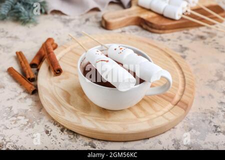 Bonshommes de neige en guimauves douces et une tasse de chocolat chaud sur fond de grunge Banque D'Images