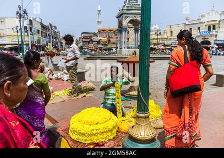 Mysore, Karnataka, Inde : Un homme vend des guirlandes de fleurs à côté de la Tour de l'horloge Dufferin en dehors du marché de Devaraja. Banque D'Images