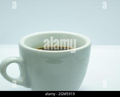 gros plan sur une petite tasse à café blanche sur fond blanc Banque D'Images