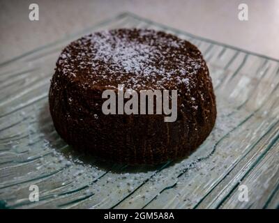 petit gâteau au chocolat recouvert de sucre en poudre Banque D'Images