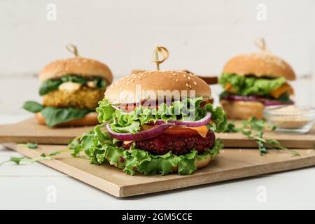 Planches en bois avec délicieux hamburgers végétariens sur la table Banque D'Images