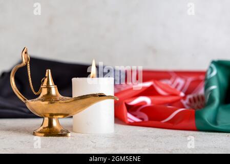 Lampe musulmane, bougie allumée et drapeau de l'Afghanistan sur table Banque D'Images