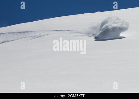 La poudre de snowboardeur tourne dans la neige fraîche en poudre avec un ciel bleu profond dans la chaîne de montagnes des Andes, au Chili Banque D'Images