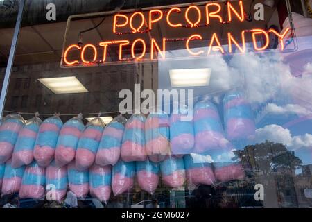 Affiche de maïs soufflé et de bonbons en coton dans la fenêtre avec présentoir de bonbons en coton Banque D'Images