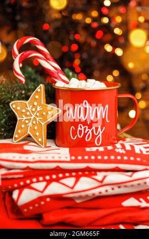 Cappuccino de Noël dans une tasse rouge sur une couverture rouge. Décorations de Noël Banque D'Images