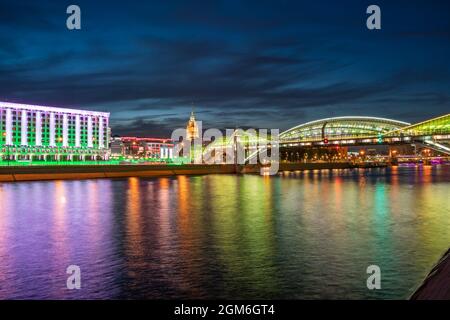 Vue sur le pont coloré Bogdan Khmelnitsky illuminé la nuit et réfléchissant dans la rivière Moskova. Gare de Moscou Kiyevsky la nuit. Modèle Banque D'Images