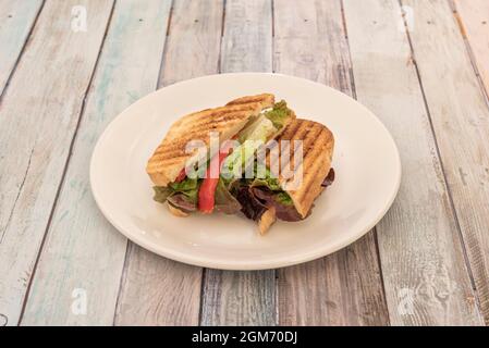 Sandwich vegan avec poivrons et laitue à l'intérieur du pain coupé en tranches avec les marques de rôti au gril Banque D'Images