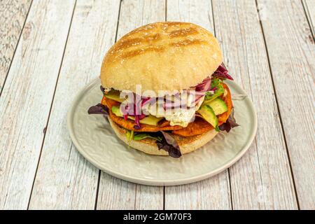 Sandwich péruvien avec avocat, œuf frit, banane mûre en chips, oignon rouge et assortiment de pousses de laitue Banque D'Images