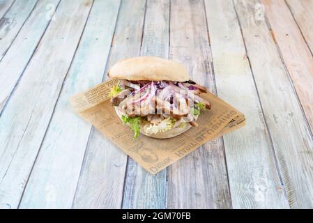 sandwich avec viande hachée de kebab rôti, oignon rouge cru et endive verte sur un rouleau rustique Banque D'Images