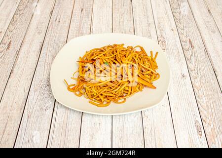 Nouilles simples sautées avec des légumes cuits dans un restaurant chinois avec beaucoup de sauce soja Banque D'Images