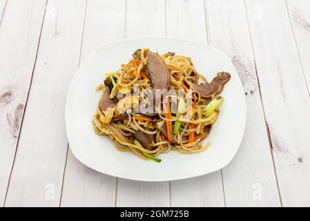 Assiette de nouilles de restaurant asiatiques sautées avec de la viande de canard, des pousses de haricots, des légumes et des œufs frits Banque D'Images