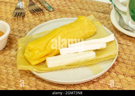 Tamale d'humita salée de style péruvien avec fromage servi sur la cosse de maïs jaune Banque D'Images