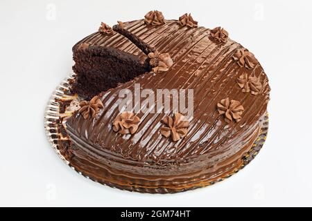 Grand gâteau au chocolat avec deux couches de gâteau éponge et une fantastique glaçage glacé avec deux portions manquantes Banque D'Images