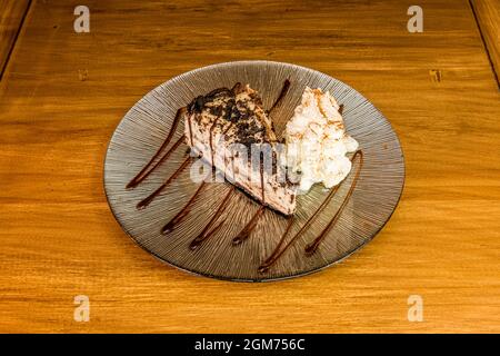 Portion de gâteau éponge oreo au sirop de chocolat chaud et à la crème fouettée Banque D'Images