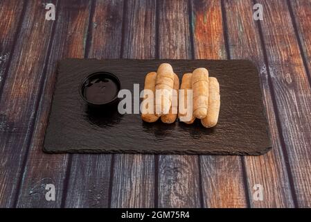 portion de tequeños farcie de fromage frais et sauce à tremper Banque D'Images