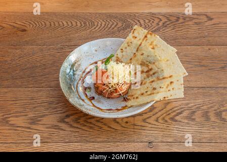 Tartare de saumon avec œufs de poisson, fromage râpé, algues, sauce soja et chips de pommes de terre Banque D'Images