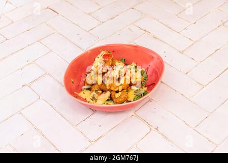 bol rouge avec tempura de crevettes rouges, roes rouges et ciboulettes sur table carrelée de blanc Banque D'Images