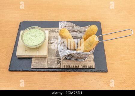 Mini-panier de friteuse avec tequeños farcis et sauce trempée Banque D'Images