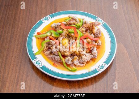 Assiette de boeuf en lanières avec des tranches de légumes sautées dans le wok cuisiné avec une recette chinoise de boeuf de Hong Kong dans une assiette avec des dragons verts Banque D'Images