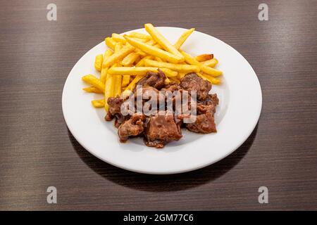 Sauce au veau avec pommes de terre garnies de pommes de terre frites sur une assiette blanche Banque D'Images