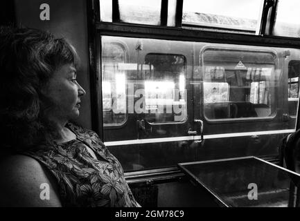 Voyage en train à vapeur - une femme voyageant dans un train à vapeur d'époque, Royaume-Uni.Voir aussi 2GM788E Banque D'Images