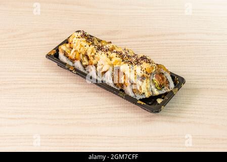 Uramaki farci de thon rouge et d'avocat avec sauce mayonnaise et graines de sésame et de pavot Banque D'Images