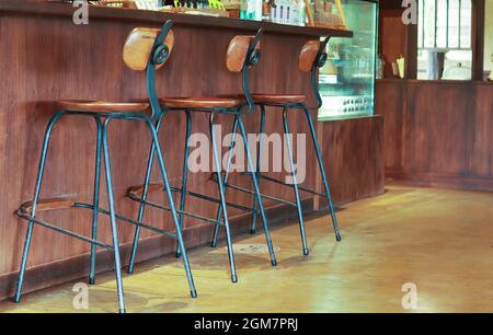 Tabouret de bar avec dossier en bois, pieds en acier. Situé en face du bar dans le restaurant. Banque D'Images
