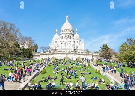 PARIS, FRANCE - 07 AVRIL 2018 : les touristes se promènent à Montmartre près de la basilique du Sacré-cœur (conçue par Paul Abadie, 1914) - Eglise catholique romaine et mi Banque D'Images