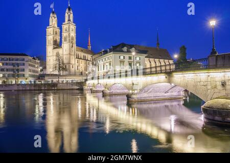 Belle vue sur le centre-ville historique de Zurich avec la célèbre église Grossmunster et Munsterbucke traversant la rivière Limmat au crépuscule en été, ca Banque D'Images