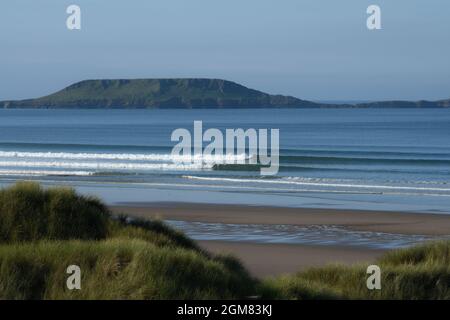 Idéal pour surfer sur la plage de sable de Llangenith Gower avec Worms Head - Rhossili à l'horizon plage de sable bleu de mer et un cadre emblématique. Banque D'Images