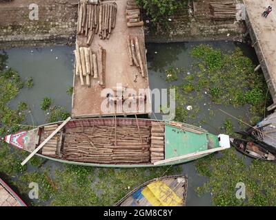 Narayanganj, Dhaka, Bangladesh. 17 septembre 2021. Les travailleurs déchargent de gros grumes de bois d'un bateau sur la rive de la rivière Sitalaksya à Narayanganj, au Bangladesh. Les grumes proviennent de différentes parties du pays sur ce marché du bois. (Image de crédit : © Joy Saha/ZUMA Press Wire) Banque D'Images