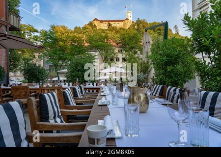 Toutes les tables sont à votre disposition dans un restaurant de Ljubljana avec une belle vue sur le château Banque D'Images