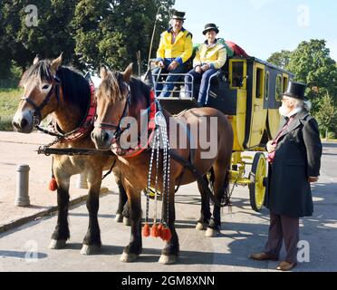 14 septembre 2021, Saxe, Leipzig: Le Coachman Siegfried Händler est assis avec sa sœur Kerstin Händler sur la boîte de son stagecoach historique devant le Monument à la bataille des Nations avant un voyage de Leipzig à Dresde. Le professeur Frank Roch (r) attendait le voyage, qui avait un tailleur spécialement conçu pour le voyage. La calèche jaune, réplique de 1830, est tirée par les chevaux à sang froid 'Evi' (l) et 'Frau Krause' et a de la place pour neuf personnes. L'offre inhabituelle appartient à la compagnie de coach de Händler à Bad Düben et est destinée à donner un goût aux voyageurs patients Banque D'Images