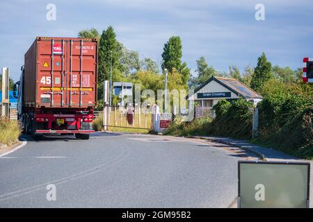 Camion-conteneur sur l'île de grain A228 passant au-dessus d'un passage à niveau manuel au passage à niveau de grain Banque D'Images