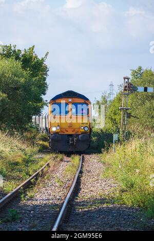 La classe 66 du fret ferroviaire de GB s'est arrêtée au signal de Semaphore sur l'île de grain en attendant le dédouanement pour traverser A228 à grain Crossing Banque D'Images