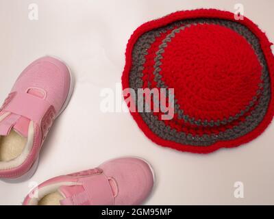 Photo de couleur rouge avec un chapeau crochet à rayures grises et une paire de chaussures roses. Prenez des photos sur un arrière-plan blanc isolé Banque D'Images