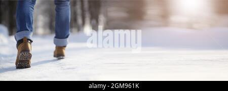 Marches le long de la piste enneigée. Un homme marche dans le parc en hiver. Banque D'Images