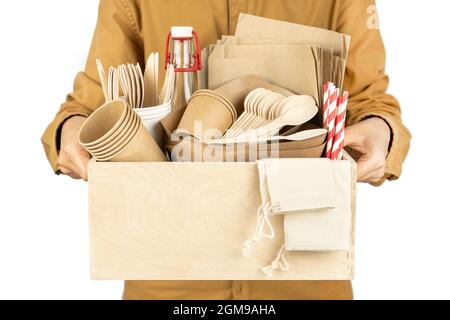 Baner avec un coursier tenant une boîte avec des plats écologiques pour la restauration rapide et les parasites isolés sur un fond blanc. Dans ses mains, elle tient une boîte en bois avec un esprit Banque D'Images