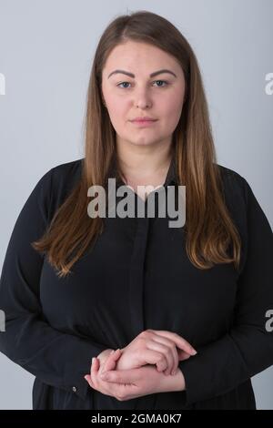 Portrait de studio de femme de taille plus montrant l'expression neutre. Femme en surpoids grave posant Banque D'Images