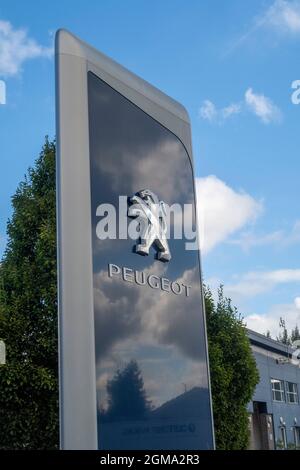 Logo et panneau de voiture Peugeot à l'extérieur de la salle d'exposition du concessionnaire automobile, Exeter Banque D'Images
