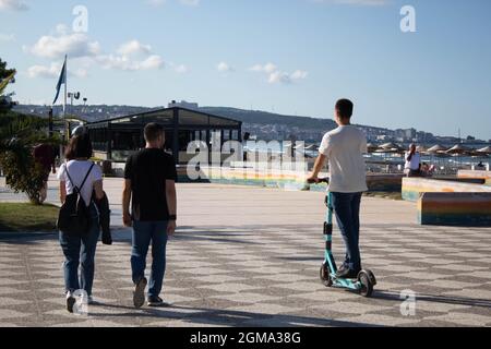 un homme heureux marchant avec sa petite amie et regardant un homme qui fait du scooter. la vie est suffisante pour profiter de chaque instant. Banque D'Images