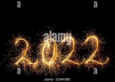 Bonne année 2022. Numéro 2022 Sparklers étincelants écrits isolés sur fond noir avec espace de copie pour le texte. Modèle de superposition brillant et créatif Banque D'Images