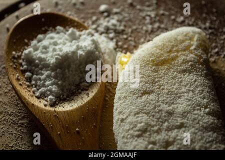 Tapioca, un plat typiquement brésilien, avec garniture de mozzarella sur une planche à découper et une cuillère en bois remplie de farine. Plat à base de farine. Banque D'Images