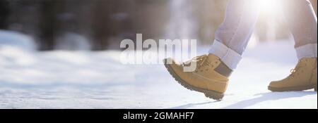 Marches le long de la piste enneigée. Un homme marche dans le parc en hiver. Banque D'Images