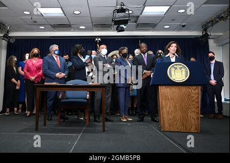 Gouv. Lt. Brian Benjamin (cravate pourpre) est derrière New York Gov. Kathy Hochul (sur le podium) lors d'une conférence de presse pour annoncer et ensuite signer la loi « moins, c'est plus » lors des cérémonies à son bureau de Manhattan, à New York, le 17 septembre 2021. Le projet de loi signé par Gov. Hochul autorise la libération de 191 détenus de la prison de l'île Rikers, car les New-Yorkais pourront éviter la prison pour la plupart des violations non violentes de la libération conditionnelle en vertu d'une nouvelle loi qui entrera en vigueur en mars 2022. Cette mesure vise à réduire l'incarcération de personnes pour violations de la libération conditionnelle technique. Banque D'Images