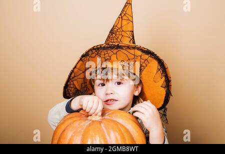 Joyeux Halloween. Enfant dans un chapeau de sorcière avec citrouille Jack. Costume de carnaval. Fête d'Halloween. Banque D'Images