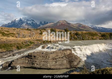 Cascade à Paine Cascades en automne avec couleurs d'automne et nuages de tempête au-dessus de Torres del Paine, Patagonie Banque D'Images