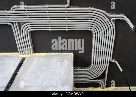 Câbles et tuyaux électriques sur le plafond en béton de la maison. Tuyaux et conduits modernes en plastique avec fils dans la pièce. Lignes de tubes de câblage en pvc après la professiono Banque D'Images