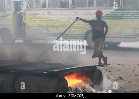 Dhaka, Bangladesh. 17 septembre 2021. DHAKA, BANGLADESH - 17 SEPTEMBRE 2021 : Un travail de route migrant fond des minéraux d'asphalte sur de petites pierres pour faire un mélange dans le cadre du resurfaçage d'une route dans l'une des banlieues de Dhaka, les employés travaillent dur plusieurs heures au soleil pour maintenir les rues et les routes de la ville en bon état. Le 17 septembre 2021 à Dhaka, au Bangladesh. (Photo de Tanvir Ahammed/ Eyepix Group) crédit: EYEPIX Group/Alamy Live News Banque D'Images