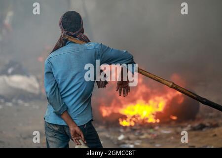 Dhaka, Bangladesh. 17 septembre 2021. DHAKA, BANGLADESH - 17 SEPTEMBRE 2021 : Un travail de route migrant fond des minéraux d'asphalte sur de petites pierres pour faire un mélange dans le cadre du resurfaçage d'une route dans l'une des banlieues de Dhaka, les employés travaillent dur plusieurs heures au soleil pour maintenir les rues et les routes de la ville en bon état. Le 17 septembre 2021 à Dhaka, au Bangladesh. (Photo de Tanvir Ahammed/ Eyepix Group) crédit: EYEPIX Group/Alamy Live News Banque D'Images